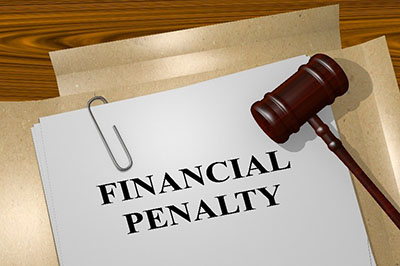 Judges gavel lying on top of an open folder with financial penatly written on it.