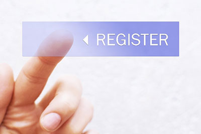 A button with the word register on it with a hand with its index finger extended to click the button.