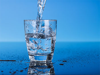 Drinking water pouring into a glass